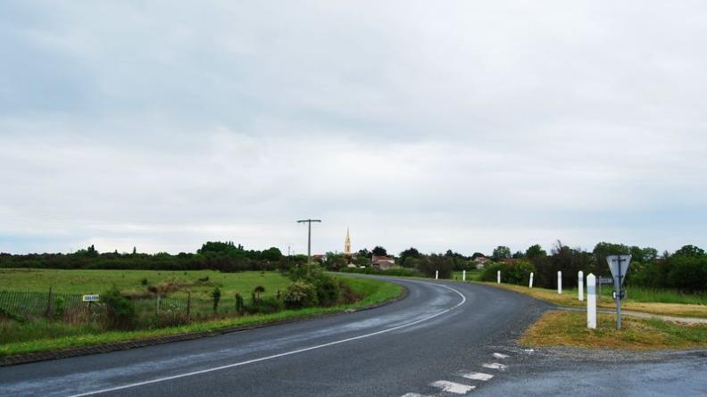 En arrivant depuis le nord, le village se signale par une densité végétale plus importante et par la silhouette de son clocher - Talais