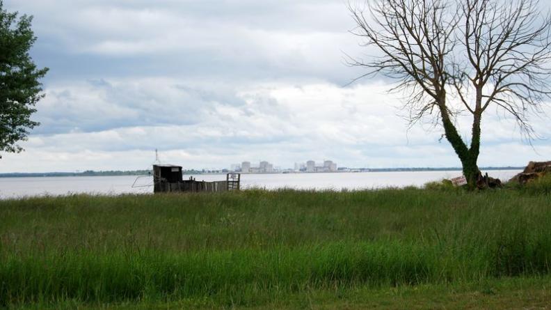 Architecture minimale des berges, la cabane à carrelet fait ici face à l'imposante silhouette de la centrale nucléaire du Blayais - Saint-Estèphe