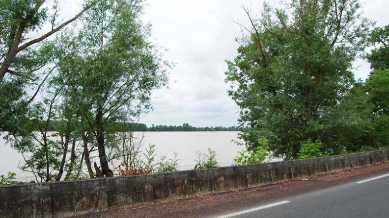 Au-delà de la digue de béton, la Garonne se découvre dans toute son ampleur par cette ouverture dans la ripisylve : l'estey du Maine crée cette configuration en se jetant dans le fleuve - Ambès