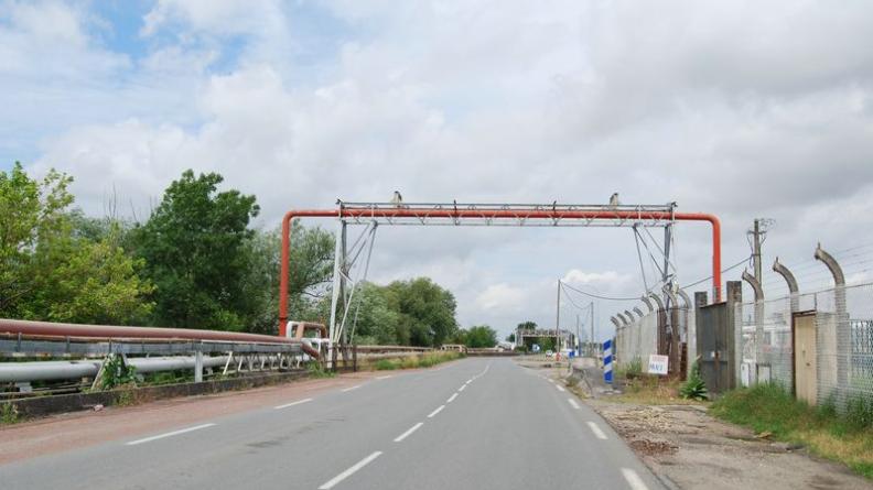 Les pipelines accompagnent ou franchissent la route, également accompagnée de clôtures et parkings peu amènes, tandis que la Garonne reste invisible - Ambès