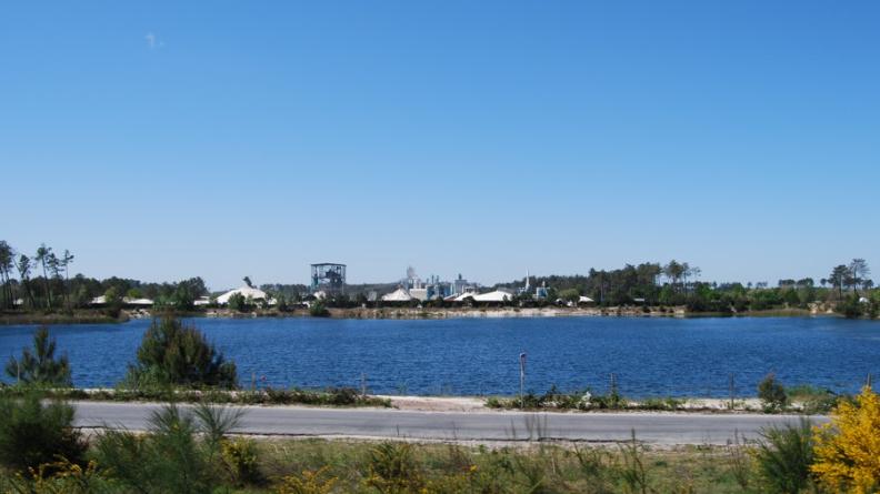 Plan d'eau résultant d'une ancienne sablière au premier plan, site en activité à l'arrière-plan, Mios