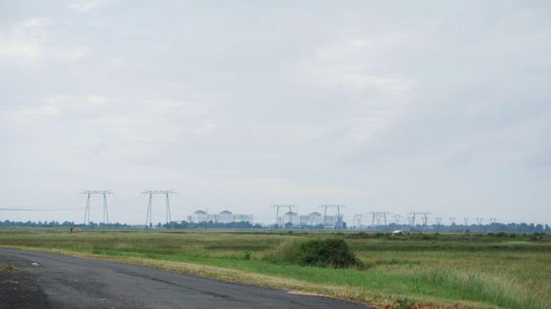 La masse imposante de la centrale est visible de très loin, émergeant au-dessus des arbres - Braud-et-Saint-Louis