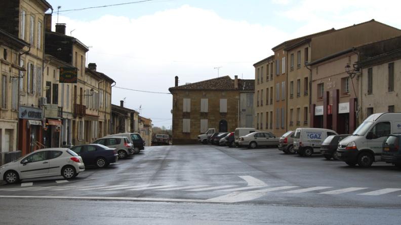 Malgré l'espace disponible sur la voie, les véhicules sont stationnés juste au pied des façades, n'offrant aucun recul aux trottoirs et peu de confort aux piétons - Castillon-la-Bataille
