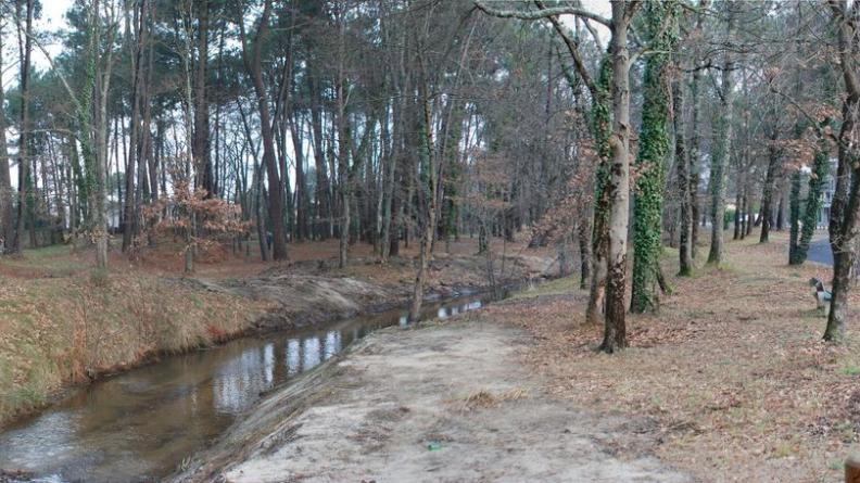 Les bords préservés du ruisseau permettent d'accueillir une piste cyclable à proximité de l'entrée de ville de Gujan-Mestras, visible à droite.