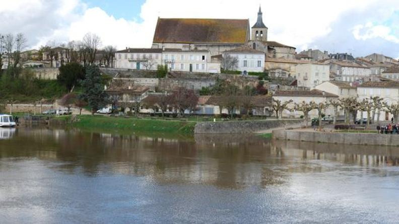 Les façades de Guîtres s'étagent, des quais maçonnés jusqu'au toit de l'abbatiale
