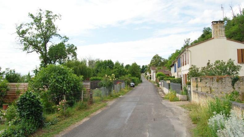 L'étroite route se glisse entre les jardins, côté estuaire, et les maisons, au pied de la falaise