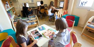 jeunes lisant et adultes consultant des ordinateurs dans une bibliothèque