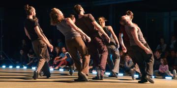 un groupe de danseurs se produit sur une scène