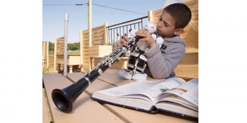 Thymoty un jeune musicien de l'orchestre Démos joue de la clarinette