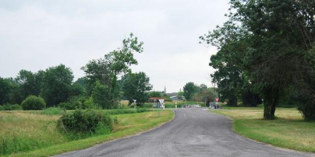 Vue depuis le canal de Ceinture : les pentes s'élèvent doucement, l'église signale le bourg de Braud derrière les arbres, légèrement surélevé - Braud-et-Saint-Louis 