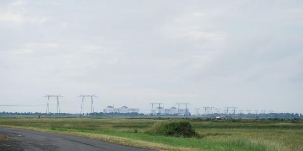 La masse imposante de la centrale est visible de très loin, émergeant au-dessus des arbres - Braud-et-Saint-Louis