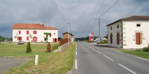 Les bâtisses et le séchoir, implantés en bord de route dans cette clairière, marquent le paysage par leur présence - Grignols 