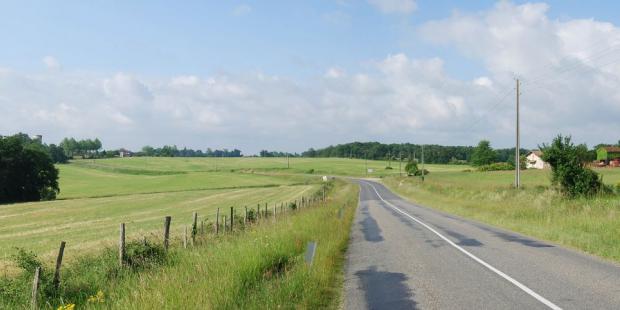 La route laisse sa marque dans le paysage en s'engravant dans ces terrains ondulés - Aillas 