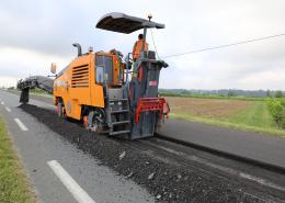 un engin réalise du bitume pour des travaux routiers écologiques et innovants sur la RD 670 à Saint Jean de Blaignac