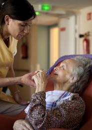 une aide soignante parle à une personne âgée dépendante